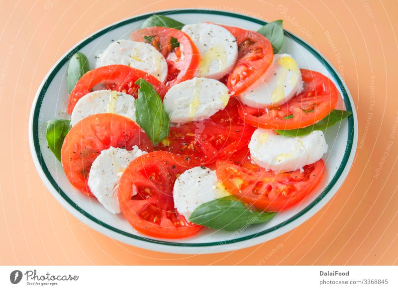 Caprese salad in brown background Cheese Vegetable Herbs and spices Nutrition Eating Diet Plate Table Fresh Red White Tradition Basil caprese salad Cooking food