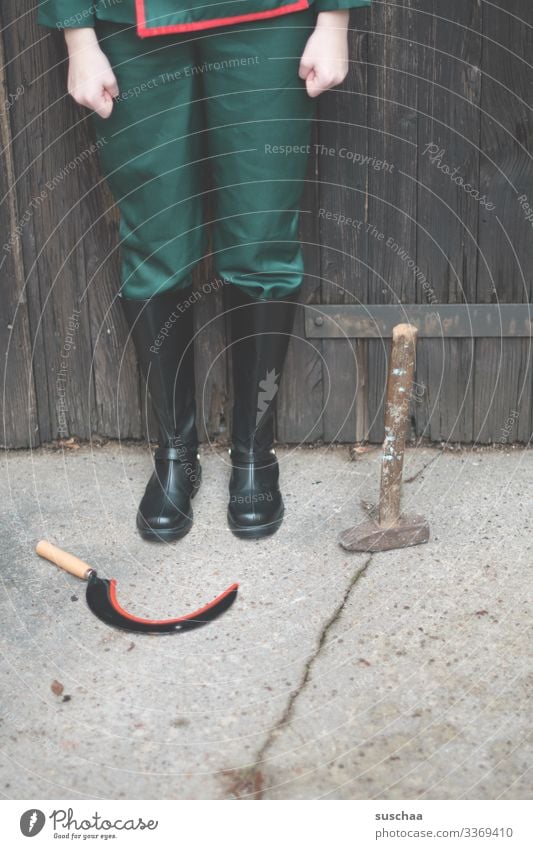 person stands with boots and clenched fists in front of a goal with hammer and sickle Uniform Boots Soldier Military Russia Youth (Young adults) War Weapon Tool