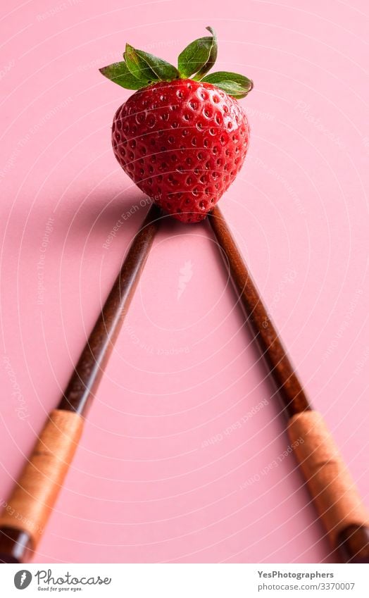 Ripe strawberry on bamboo chopsticks. Single strawberry Fruit Dessert Organic produce Vegetarian diet Fresh Natural Cute agriculture bamboo sticks Chopstick