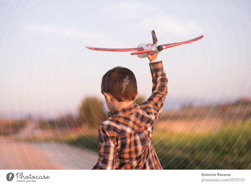 Little boy with toy airplane playing in outdoors image Playing Vacation & Travel Adventure Child Pilot Boy (child) Infancy Flower Meadow Street Airplane Toys