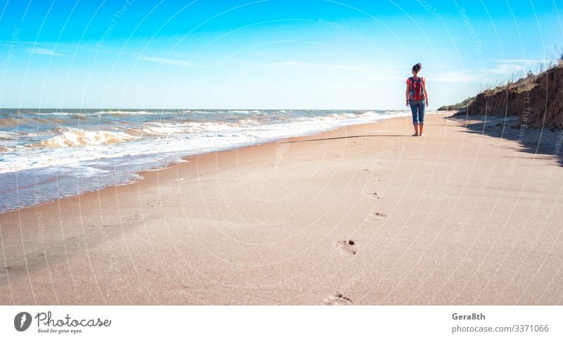 girl tourist with a red backpack on an empty sandy beach Vacation & Travel Freedom Summer Beach Ocean Waves Woman Adults Nature Landscape Sand Sky Clouds