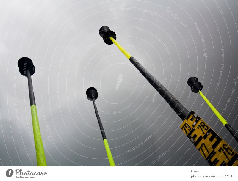 Neighborhoods | The hat players from the edge of the harbor Water level gauge 4 poles Wood plastic figures measuring rod Black Yellow Sky Clouds Storm clouds