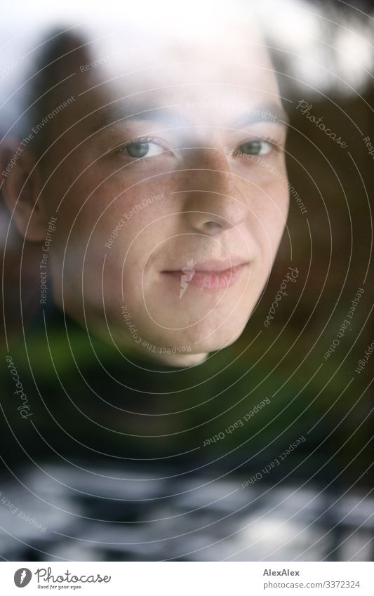 Portrait of a young man behind a window pane with reflections Style pretty Well-being Flat (apartment) Window Window pane Young man Youth (Young adults) Face