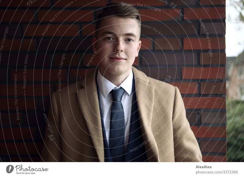 Portrait of a young man Lifestyle Style Joy pretty Brick wall Balcony Young man Youth (Young adults) 18 - 30 years Adults Beautiful weather Suit Coat Blonde