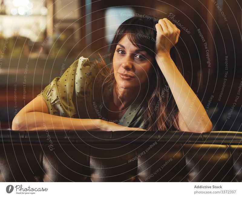 Thoughtful tired woman sitting on sofa leaning on back exhausted resting female upset alone thoughtful pensive thinking comfortable couch stylish leather