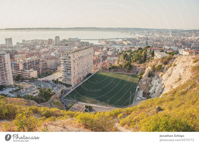 View over the roofs of Marseille with sports field Sunlight Light Copy Space top Panorama (View) Colour photo Deserted Day Roof City life tree Vantage point