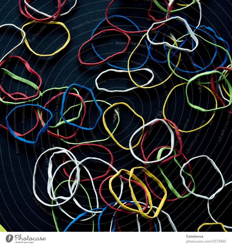 Challenge |Colorful rubber bands lie scattered on black background Elastic band Dark Multicoloured Black Adaptable Colour Environmental pollution Close-up