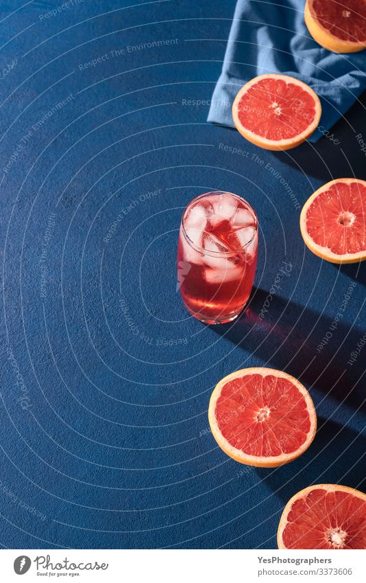 Grapefruit drink and slices citrus fruits. Grapefruit halves Fruit Beverage Cold drink Lemonade Juice Glass Fresh Juicy Colour Blue background blue table