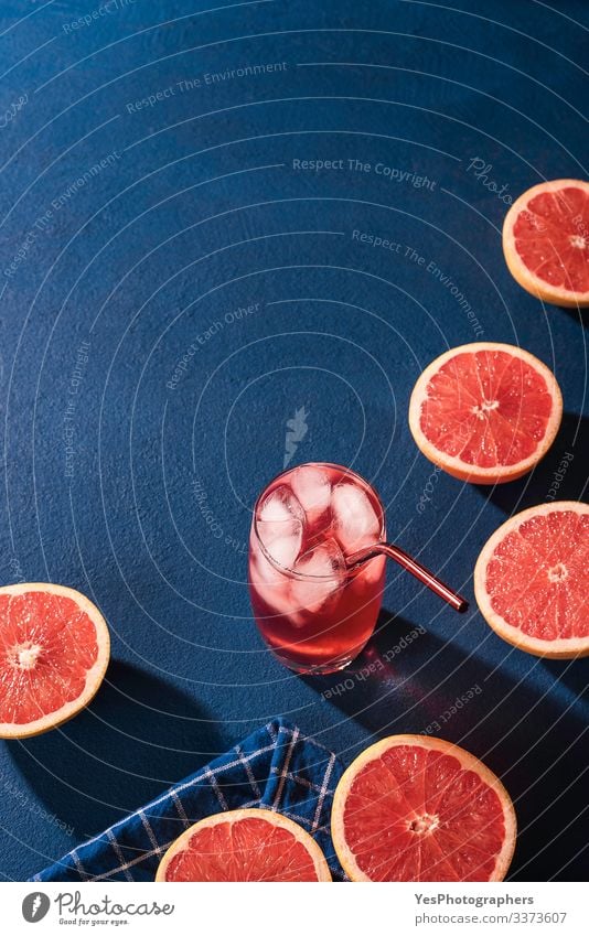 Organic grapefruit slices and cold drink. Lemonade Fruit Beverage Cold drink Juice Glass Fresh Juicy Colour Blue background blue table Citrus fruits