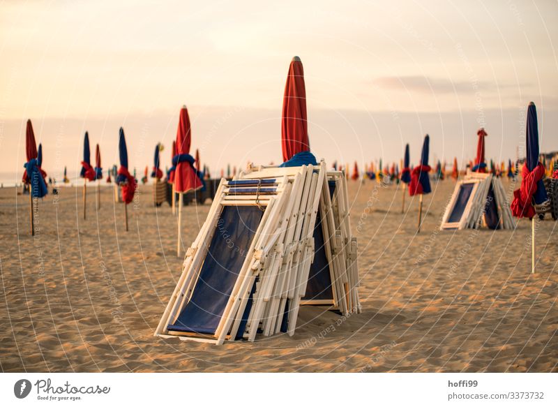 wrapped umbrellas and beach chairs at sunset on the beach of Deauville Environment Sand Sky Clouds Sunrise Sunset Beautiful weather Coast Ocean Beach Sunshade