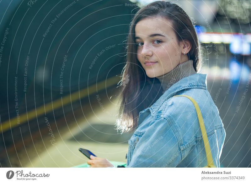 Teenager girl with backpack and smartphone on metro station Decoration Blog To feed Easygoing Casual clothes Chat Chatty City Destination Europe Finland