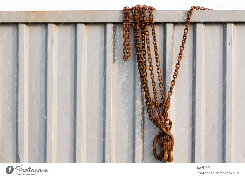 rusty chain hanging over a container Container Chain Checkmark Rust Metal Steel Line Stripe Old Sharp-edged Simple Firm Large Above Retro Strong Effort