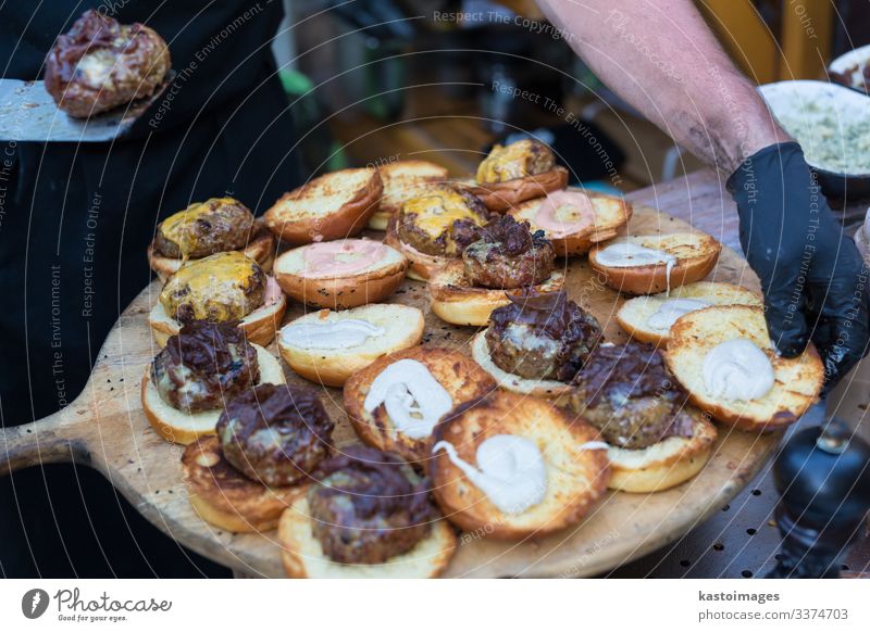 Chef making beef burgers outdoor on food festival event. Meat Roll Lunch Plate Desk Kitchen Restaurant Street Gloves Going Make Delicious Black catering chef