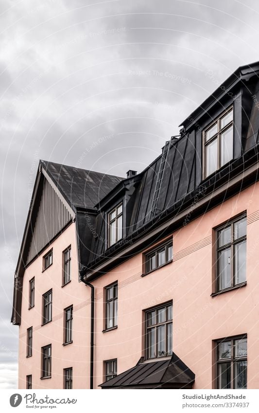 Pastel colored building with black roof house windows rooftop Europe European Stockholm Sweden Swedish Scandinavia Scandinavian attic urban city town pastel