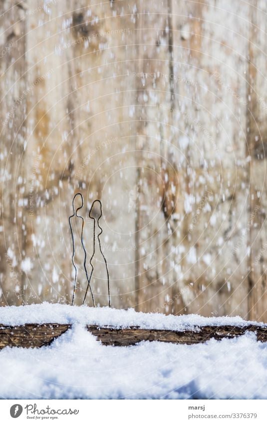 A couple is taking a walk over a snowy board in snowfall Central perspective Contrast Light Copy Space top Close-up Subdued colour Colour photo Stick figure