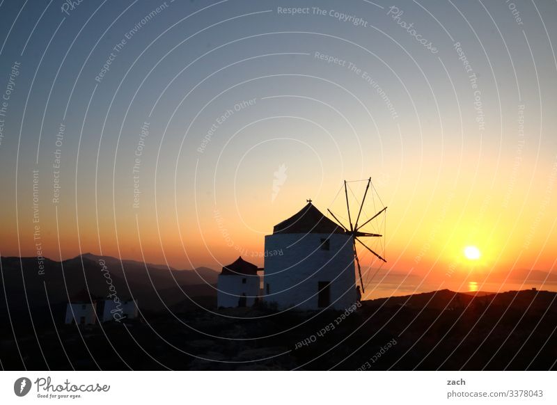 old windmills at sunset on an island in Greece the Aegean Cyclades Ocean Island Mediterranean sea Exterior shot Twilight Long exposure Deserted Copy Space top