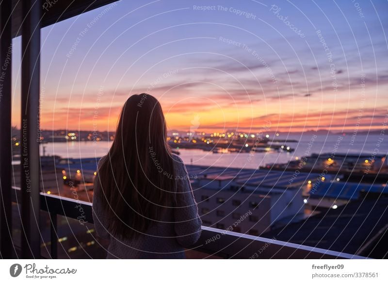 Young woman contemplating the sea from a balcony Vigo Galicia Spain ocean horizon altitude sunset sky clouds night shoreline coastal port water buildings