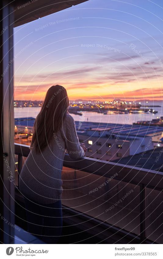 Young woman contemplating the sea from a balcony Vigo Galicia Spain ocean horizon altitude sunset sky clouds night shoreline coastal port water buildings