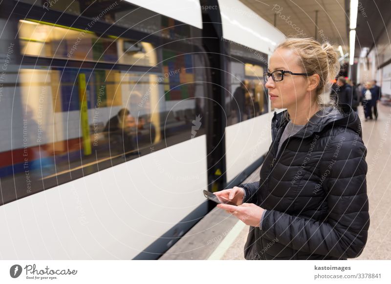 Woman with a cell phone waiting for metro. Lifestyle Vacation & Travel Trip Decoration Telephone Cellphone PDA Human being Adults Transport Railroad Underground