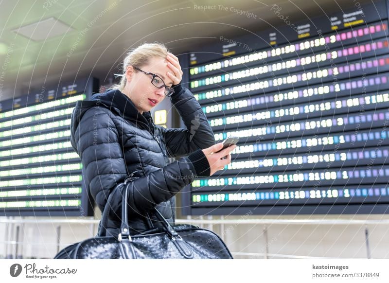 Woman at airport checking flight information on phone app. Vacation & Travel Tourism Trip Winter Decoration Telephone PDA Aviation Human being Adults Airport