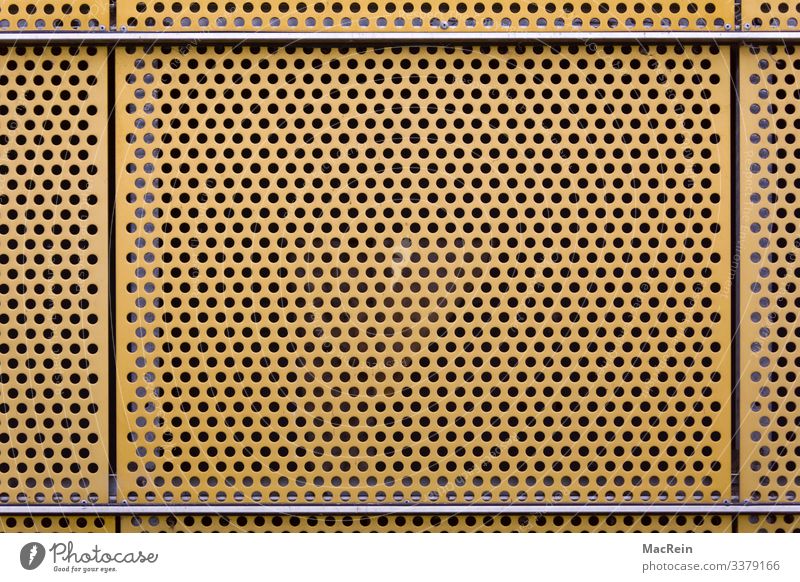 perforated sheet Metal Yellow Tin Plate with holes Wall cladding Hollow Deserted Copy Space Colour photo Exterior shot Day