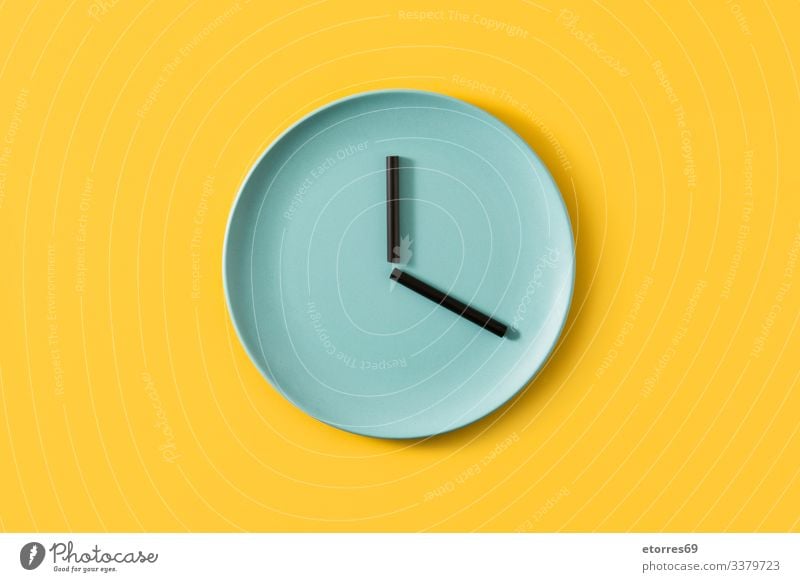 Clock made with plate and straws on yellow background clock food empty time concept kitchen kitchenware blue black eat time to eat color hour minute second Time