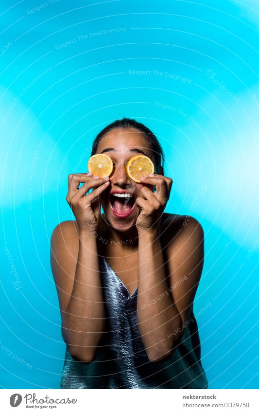 Young Woman Holding Lemon Slices Over Eyes Smiling Widely slice female girl eyes holding up concept minimalism citrus fruit fresh freshness smile happiness