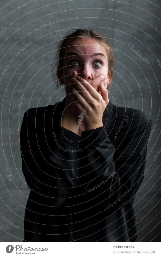 Young Caucasian Woman with Hands on Mouth and Frightened Facial Expression hands on mouth scream female girl woman young adult terror horror silence quiet hush