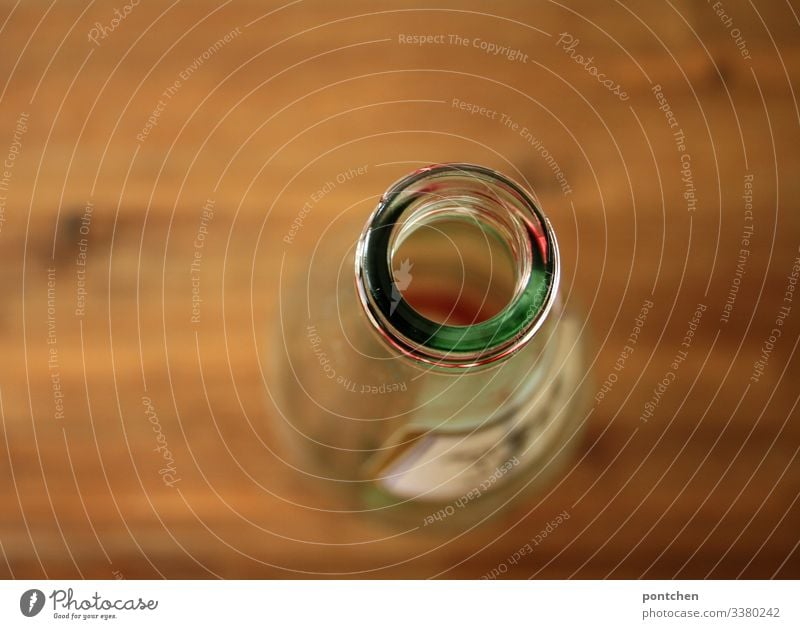 Empty glass bottle from above on wooden table Shopping Flat (apartment) Cold Sustainability Glass Table Stand Shallow depth of field Corner Deposit bottle