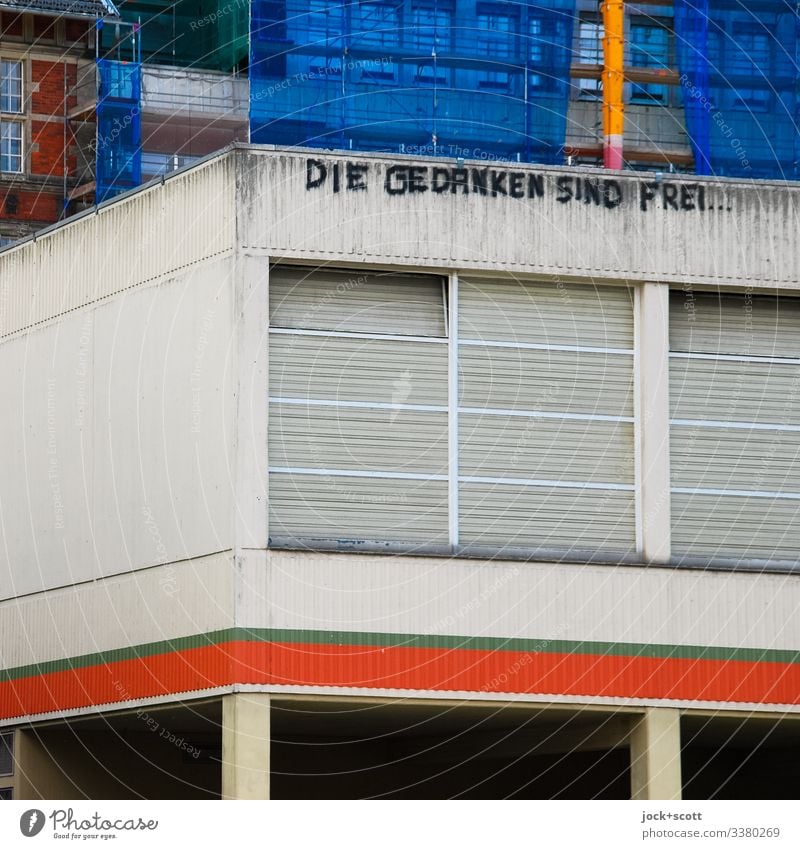 Thoughts are free on a building made of concrete Building Concrete Architecture Facade Gray street art Window Structures and shapes Corner Roller shutter Closed