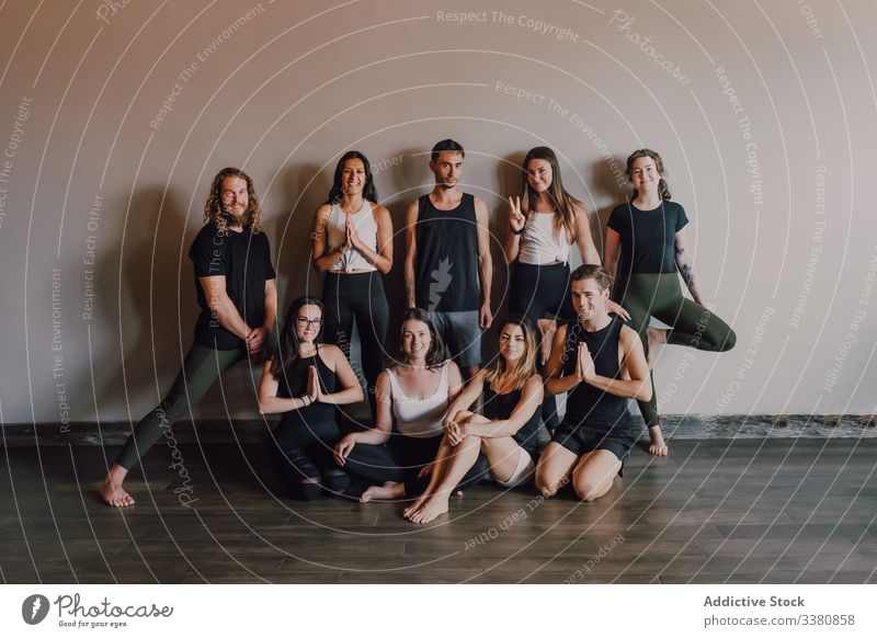 Group of joyful athletes in various yoga poses in contemporary workout room class balance practice happy training studio namaste club stretch people smile