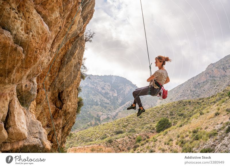 Female climber enjoying mountaineering woman alpinist hang cliff ascend terrain female adventure extreme risk active challenge adrenalin freedom altitude rope