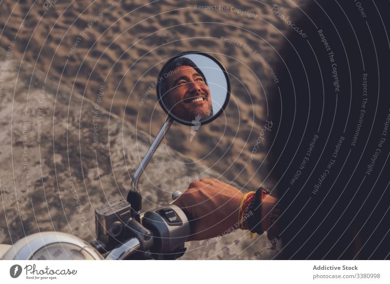 Happy man riding bike on beach sand happy mirror reflection enjoy summer cheerful positive adventure travel modern male journey trip nature vacation ride