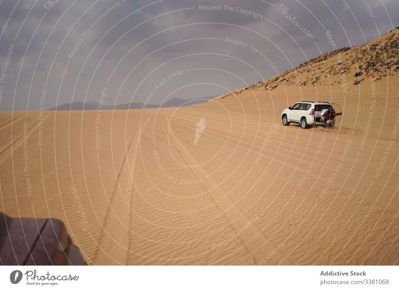 Dramatic landscape of vehicle on desert road scenery car drive stormy sky transport travel journey nature sand dramatic adventure terrain tourism trip auto