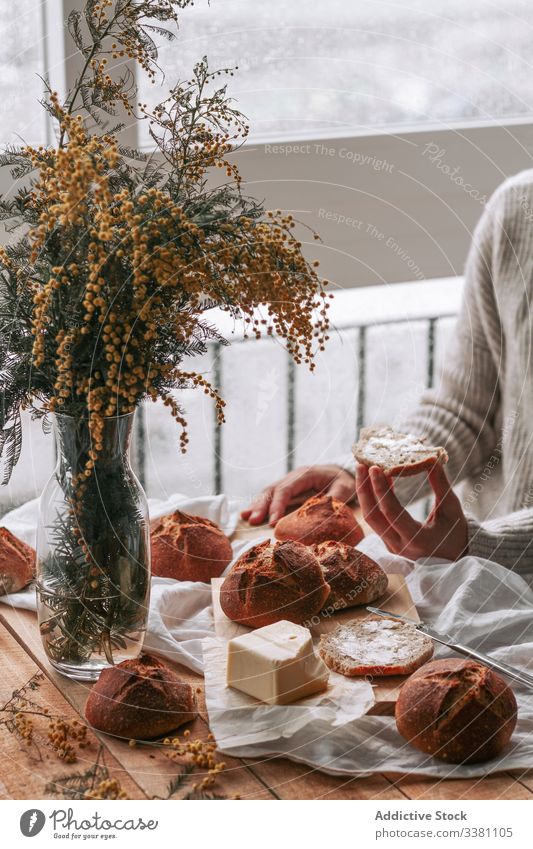 Faceless lady spreading butter on bread in kitchen mimosas woman cook morning breakfast prepare table home flower female lunch culinary slice pastry vase