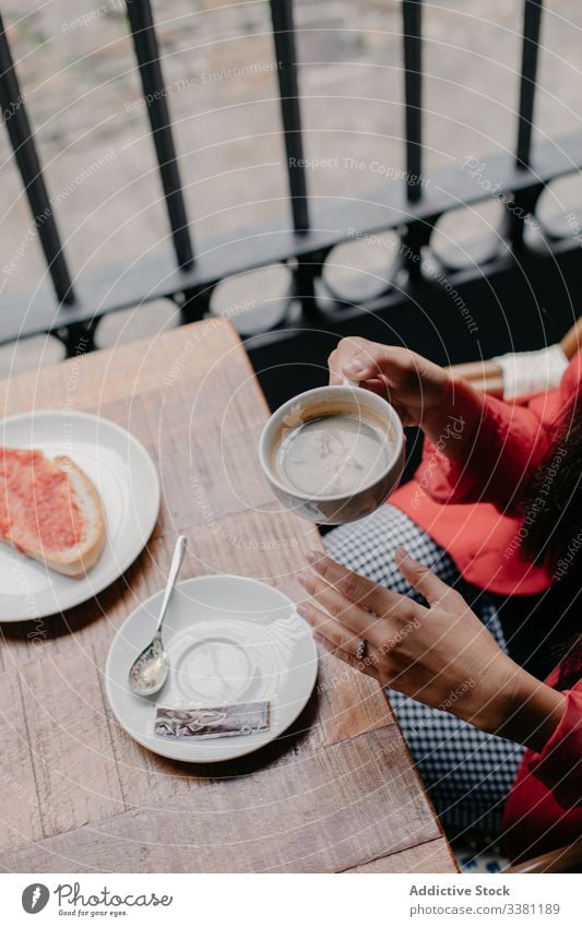 Woman drinking coffee in cafe woman breakfast table cup newspaper morning relax rest cafeteria casual lifestyle modern young beverage food hot indoors blur