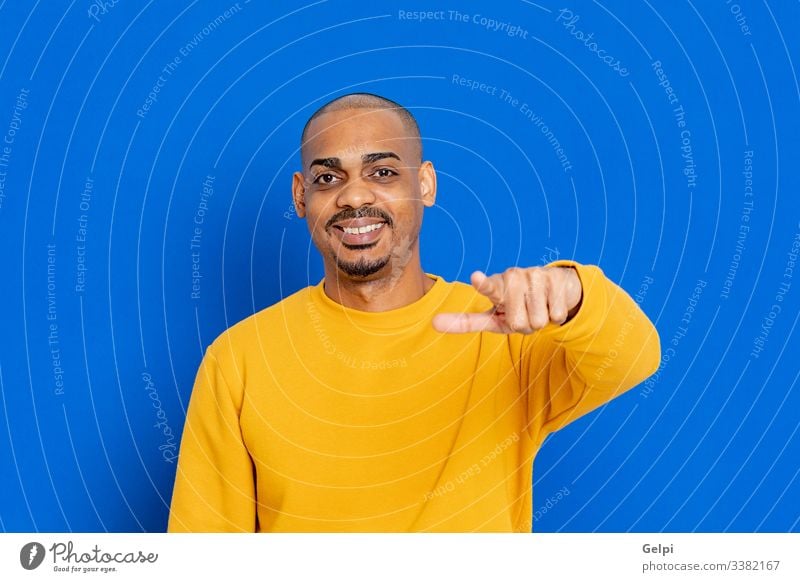 African guy with a yellow jersey black blue hand you pointing accuse laugh indicate selecting selection finger adult people person african male american man