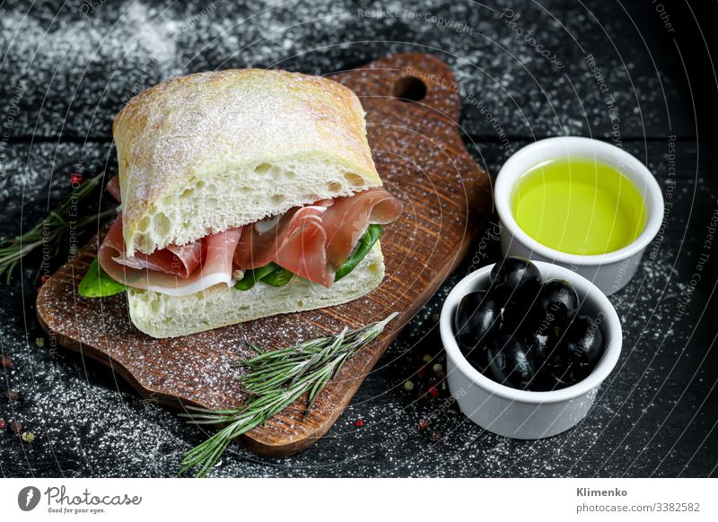 Ciabatta sandwich with arugula salad, spinach leaves, bacon. ciabatta olives rosemary oil olive oil italy bruschetta food flour breading crust snack drink