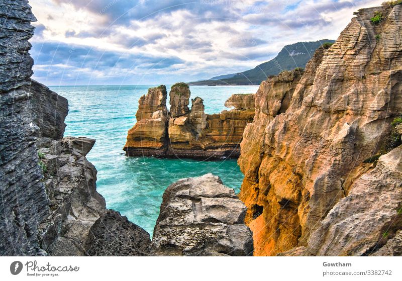 Pancake Rocks near Hokitika on New Zealand's south island. beautiful cliff cloud cloudy coast coastal color colorful colour colourful crash crashing door doors