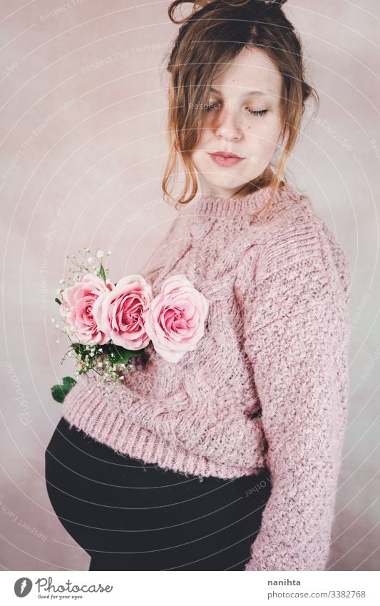 Young pregnant woman holding a bouquet of roses pregnancy mom waiting family love third trimester month weeks natural real candid real woman people flowers pink