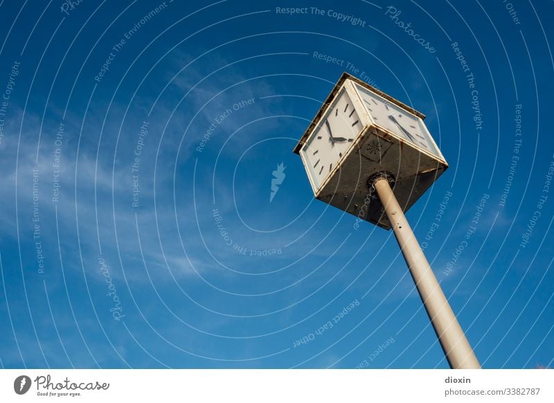 Old, defective city clock, showing two different times, in front of a blue sky with white clouds of veil Clock Clock hand Time timing Digits and numbers