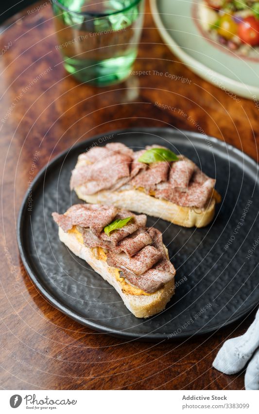 Fresh ham sandwiches on black plate in restaurant toast food tasty delicious meal fresh snack gourmet dish yummy breakfast bread lunch rustic crunch portion