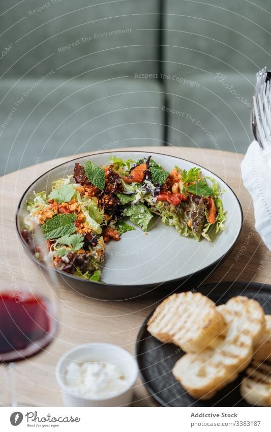 High cuisine salad with seafood and bread in restaurant haute cuisine plate dish octopus tomatoes fried roasted slice piece colorful fresh healthy greenery herb