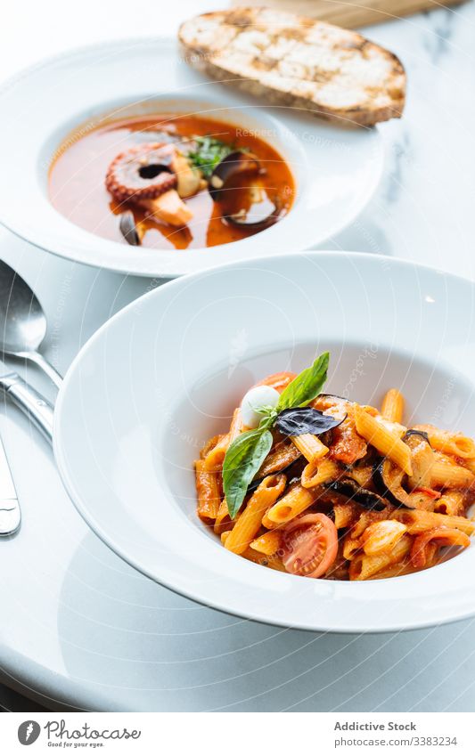 Plate with classic Italian pasta in restaurant italian dish haute cuisine vegetable slice piece tomato eggplant sauce basil noodle bowl fresh serve tradition