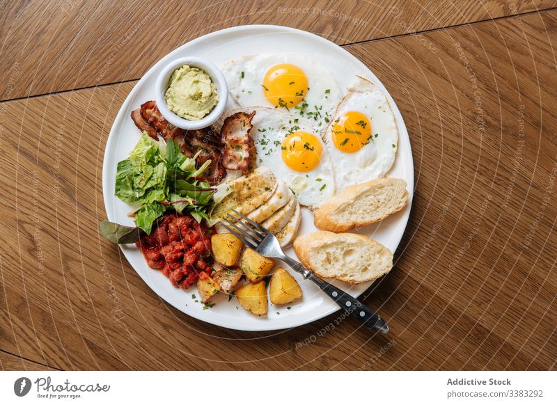 Delicious breakfast meal with fried eggs and veggies english toast bacon vegetable bean potato salad cuisine dish plate calorie guacamole modern morning