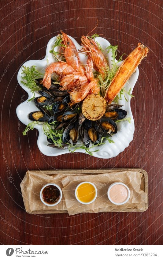 Seafood appetizer plate with assortment of sauces seafood prawn grill mussel delicacy culinary restaurant cafe delicious dish sweet chili sauce thousand island