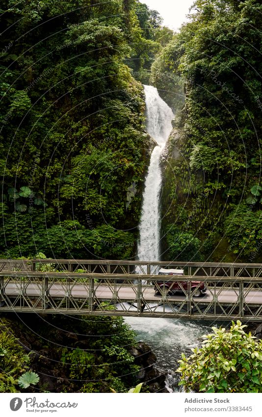 Retro car on bridge near waterfall jungle ride retro green nature costa rica transport vehicle auto vintage stream flow river forest landscape scenic cascade