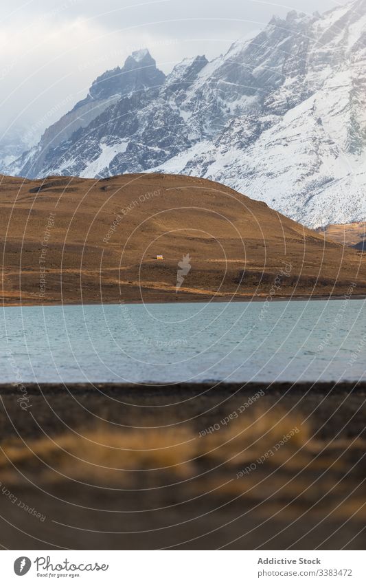 Beautiful scenery of river in valley against foggy snowy mountains cloud dramatic peak shore sky water highland island coast lake summit horizon landscape calm