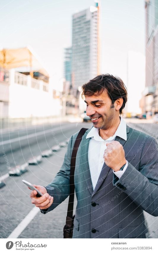 Handsome mature businessman celebrating victory achievement barcelona beard building businessperson cellphone cellular cheerful city communication concept