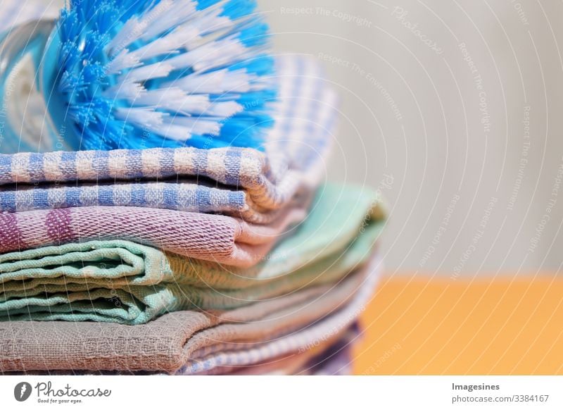 Dishcloths and dish brush on yellow background, linen and cotton cloths. Stack of coloured tea towels Kitchen Dish towels dishwashing brush Linen cloth